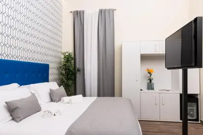 a bedroom with a white bed and a tv at St. Peter Manor in Rome