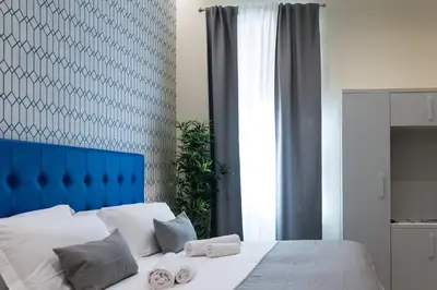 a bedroom with a blue headboard and a white bed at St. Peter Manor in Rome