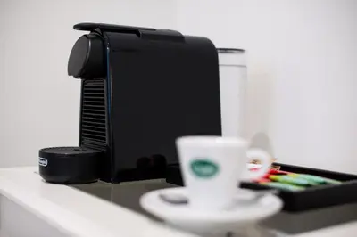 a cup sitting on a counter next to a coffee maker at St. Peter Manor in Rome