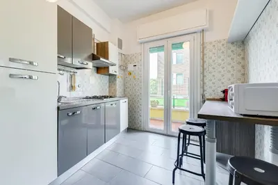 a kitchen with white appliances and a counter with stools at BDC - King Termini Apartment in Rome