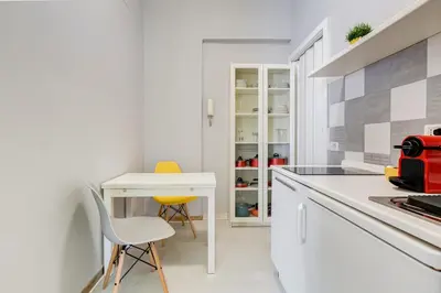 a kitchen with a white counter and a table and chairs at BDC - King Termini Apartment in Rome