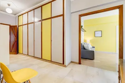 a living room with a yellow and white wall at BDC - King Termini Apartment in Rome
