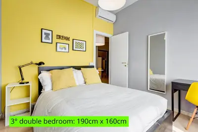 a bedroom with a bed and a yellow wall at BDC - King Termini Apartment in Rome
