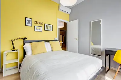 a bedroom with a bed and a yellow wall at BDC - King Termini Apartment in Rome
