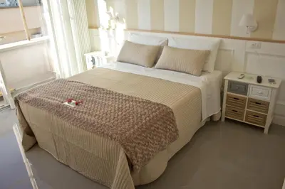 a bedroom with a large bed with a side table at Glamroom Vatican Apartment in Rome