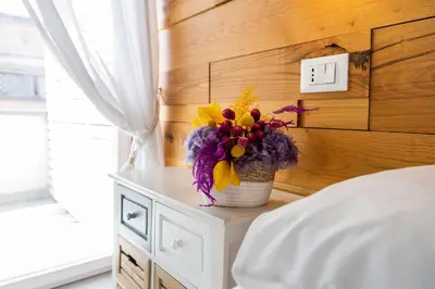 a vase of flowers sitting on a table in a bedroom at Glamroom Vatican Apartment in Rome
