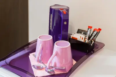 two pink cups and scissors on a tray at 2 Passi Al Colosseo B&B in Rome