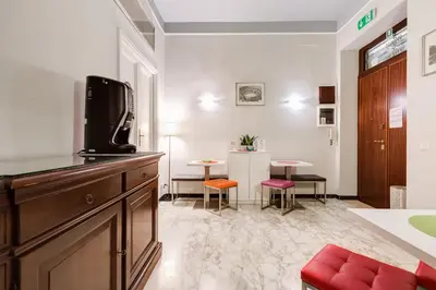 a living room with a tv and a table with chairs at 2 Passi Al Colosseo B&B in Rome