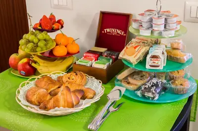 a table topped with different types of pastries and fruit at 2 Passi Al Colosseo B&B in Rome