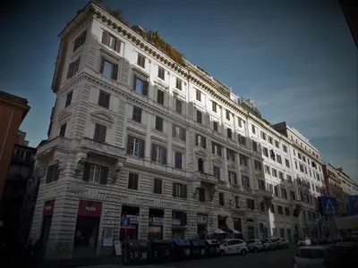 a tall white building with cars parked in front of it at 2 Passi Al Colosseo B&B in Rome