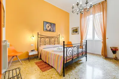 a bedroom with a bed and a chair and a window at 2 Passi Al Colosseo B&B in Rome