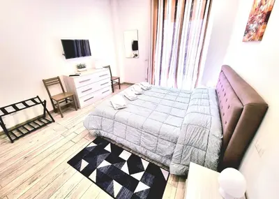 a bedroom with a bed and a dresser and a television at New Tiburtina in Rome