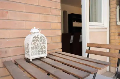 a bird cage sitting on a porch next to a wooden bench at St Peter new and lightsome apartment with balcony in Rome