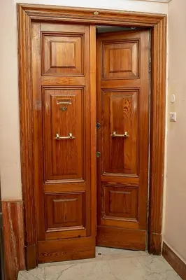 a pair of wooden doors in a room at Il Bonsai B&B in Rome