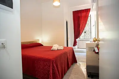 a bedroom with a red bed and a window at Il Bonsai B&B in Rome