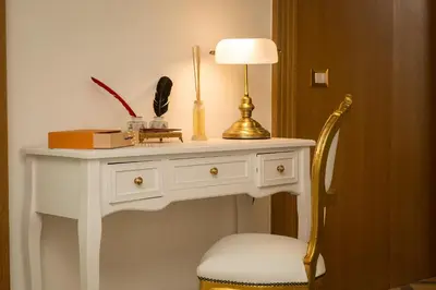 a white console table with a lamp and a chair at Giuditta Suite 121 Trastevere Roma in Rome