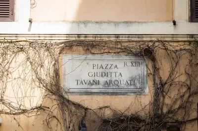a street sign on the side of a building at Giuditta Suite 121 Trastevere Roma in Rome