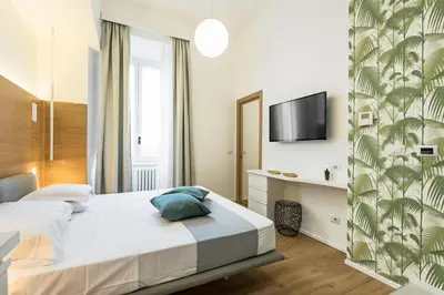 a bedroom with a bed and a tv on a wall at Numa Roma Guesthouse in Rome