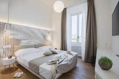 a white bedroom with a large bed and a window at Numa Roma Guesthouse in Rome
