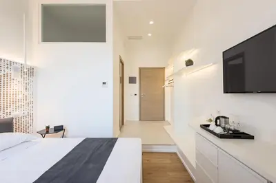 a bedroom with a bed and a flat screen tv at Numa Roma Guesthouse in Rome