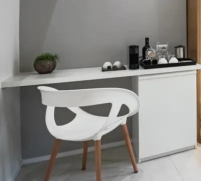 a white chair sitting in front of a counter at Numa Roma Guesthouse in Rome