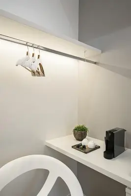 a white bathroom with a sink and a microwave at Numa Roma Guesthouse in Rome
