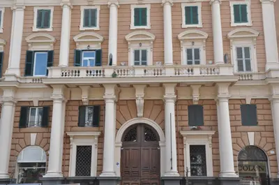 a building with a wooden door and columns at Numa Roma Guesthouse in Rome