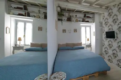 two beds in a bedroom with blue sheets at Boutique Apartment Roma in Trastevere in Rome