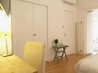 a bedroom with a yellow chair and a table at M SuiteApartment Roma in Rome