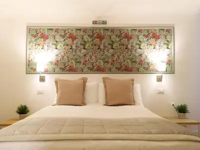a large painting above a bed with two pillows at M SuiteApartment Roma in Rome