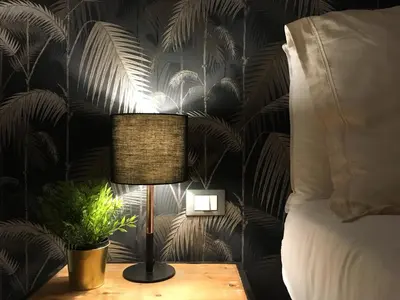 a lamp on a table next to a bed at M SuiteApartment Roma in Rome