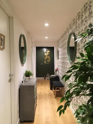 a hallway with a table and a green door at M SuiteApartment Roma in Rome