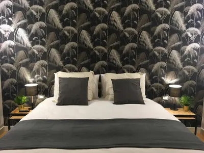 a bedroom with a bed with a black and white wallpaper at M SuiteApartment Roma in Rome
