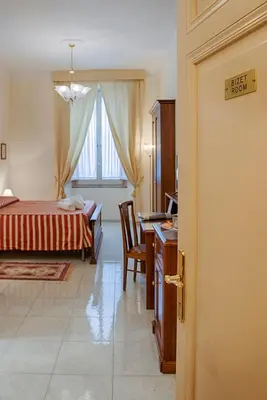 a bedroom with a bed and a desk and a table at Armonia All'Opera in Rome