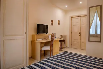 a room with a desk with a computer and a television at Armonia All'Opera in Rome