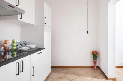 a kitchen with white cabinets and a counter top at A World Aparts - 40 Sforza in Rome