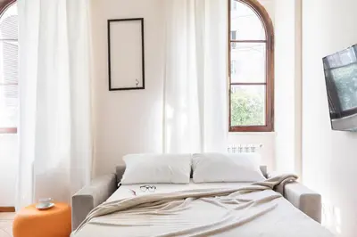 a bed in a room with white walls and windows at A World Aparts - 40 Sforza in Rome