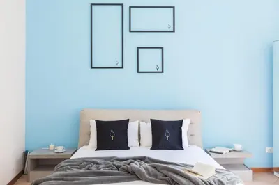a bedroom with a bed with blue walls at A World Aparts - 40 Sforza in Rome