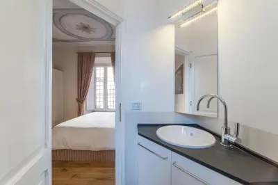 a bathroom with a sink and a mirror and a bed at Monti Stunning Apartment with Terrace in Rome