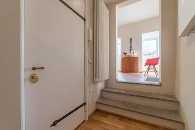 a hallway with a door and a red chair at Monti Stunning Apartment with Terrace in Rome
