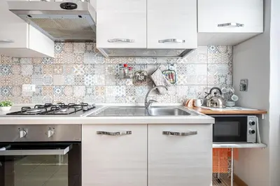 a kitchen with white cabinets and a sink at Caracciolo Apartment - Metro San Giovanni in Rome