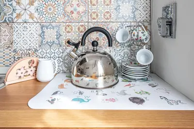 a tea kettle on a kitchen counter with plates and cups at Caracciolo Apartment - Metro San Giovanni in Rome