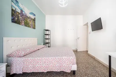 a white bedroom with a bed and a tv at Caracciolo Apartment - Metro San Giovanni in Rome