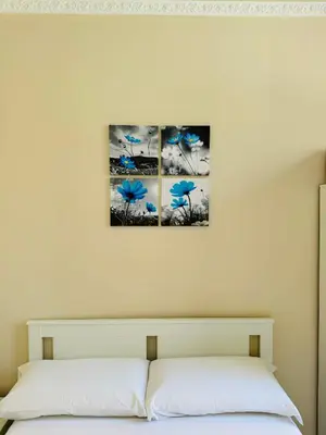 a bedroom with three blue flowers on the wall at B&B Rome Terminal House in Rome