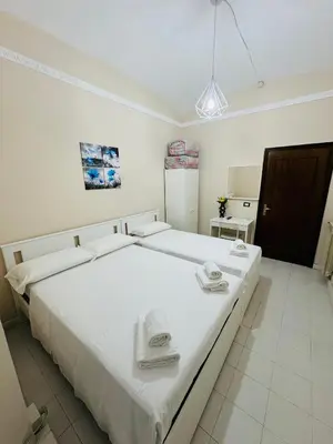 a bedroom with a large white bed with towels on it at B&B Rome Terminal House in Rome