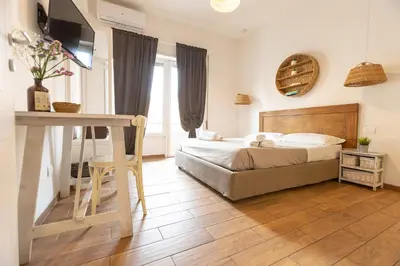 a bedroom with a bed and a desk with a television at Luma Home in Rome