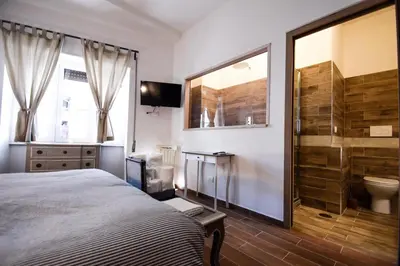 a bedroom with a bed and a bathroom with a toilet at Luma Home in Rome