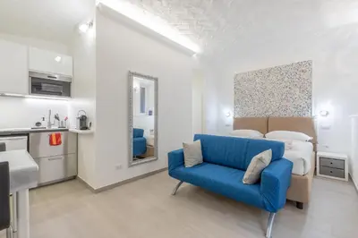 a living room with a blue couch and a bed at Dolce Vita New Studio in Rome