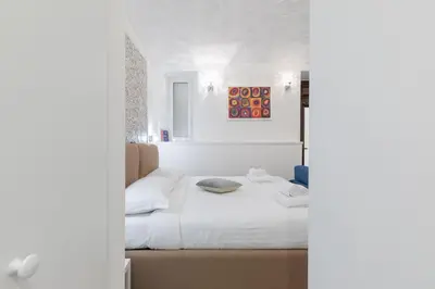 a bedroom with a bed with white sheets at Dolce Vita New Studio in Rome
