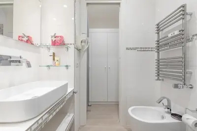 a white bathroom with a sink and a mirror at Dolce Vita New Studio in Rome